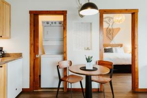 a small kitchen with a table and a bedroom at Mt Merritt Suite Boutique Hotel Experience in Kalispell