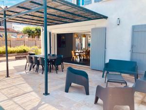 a patio with a table and chairs and a dining room at Chai Nous - votre villa au cœur des Landes - classée 4 étoiles in Rion-des-Landes