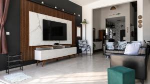 a living room with a flat screen tv on a wall at Casa no Litoral , com Piscina Privativa em Ubatuba in Ubatuba