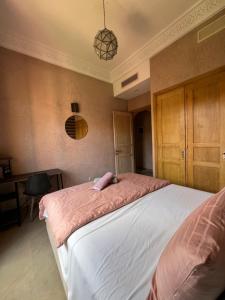a bedroom with a large bed with a pink blanket at Resort Apartment Golf View in Marrakesh +27 photos