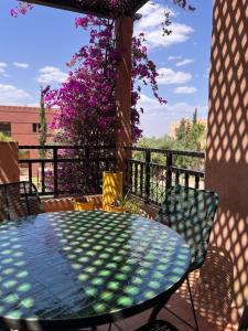 a table and chairs on a balcony with a table and flowers at Resort Apartment Golf View in Marrakesh