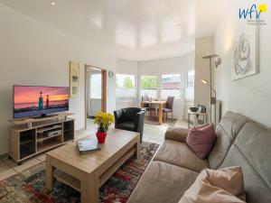 a living room with a couch and a tv at Haus Wilhelm-Feldhoff Ferienwohnung Veen in Borkum