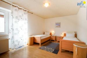 a small room with two beds and a window at Haus Wilhelm-Feldhoff Ferienwohnung Veen in Borkum
