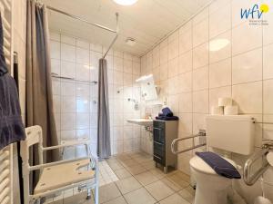 a white bathroom with a toilet and a shower at Haus Wilhelm-Feldhoff Ferienwohnung Veen in Borkum +18 photos