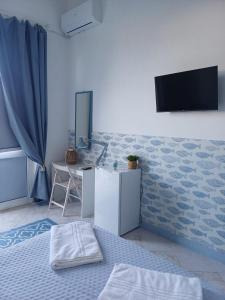 a room with a bed and a desk and a television at Le Stanze del Mare - B&B in Messina