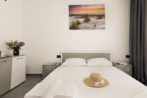 a bedroom with a bed with a hat on it at Flamingo Corbu Resort in Corbu