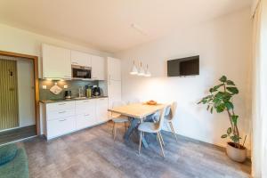 a kitchen and dining room with a table and chairs at Moar Apartments in Silandro