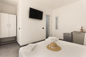 a room with a bed with a hat on it at Flamingo Corbu Resort in Corbu