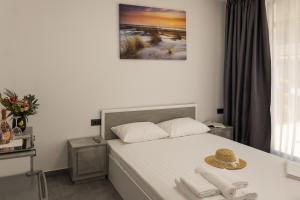 a bedroom with a white bed with a hat on it at Flamingo Corbu Resort in Corbu
