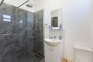 a bathroom with a shower and a sink and a toilet at Flamingo Corbu Resort in Corbu