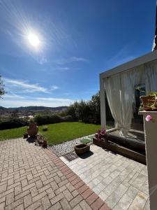 a patio with a white curtain and a building at Casa di Piera in Poggibonsi