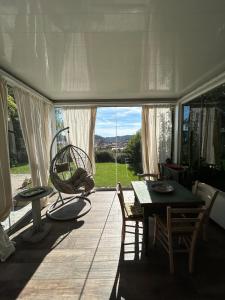a dining room with a table and a large window at Casa di Piera in Poggibonsi