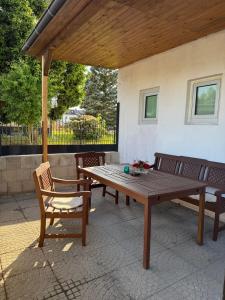 a wooden picnic table and two chairs on a patio at Apartment Natali in Schnaittenbach