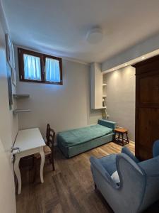a living room with a bed and a couch and a table at Casa di Piera in Poggibonsi