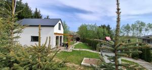a white house with a tree in the yard at Domek KAMA in Giżycko +1 photo