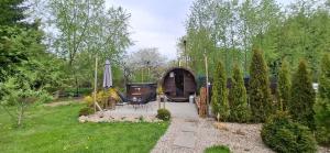 a garden with a wooden cabin with a table and chairs at Domek KAMA in Giżycko