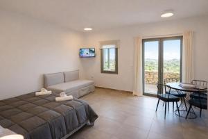 a bedroom with a bed and a table and a dining room at Aroniadika rooms in Kythira