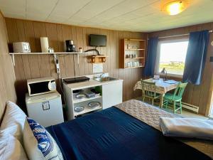 a small room with a bed and a small table at Chalets Camping Bernatchez in Mont-saint-pierre +37 photos