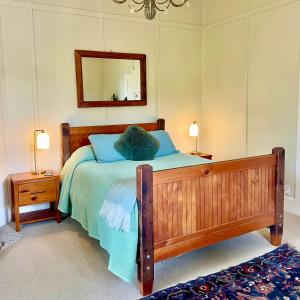 a bedroom with a bed with a mirror and two lamps at Wisteria Villa in Russell