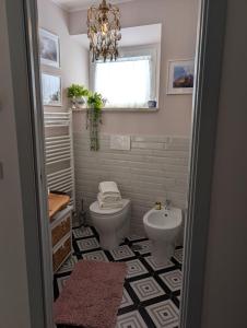a bathroom with a toilet and a sink at Casa Mita - accogliente monolocale nel cuore del paese in Marta +13 photos