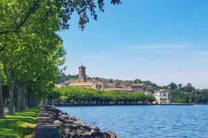a large building sitting on the side of a lake at Casa Mita - accogliente monolocale nel cuore del paese in Marta
