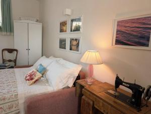a bedroom with a bed and a table with a lamp at Casa Mita - accogliente monolocale nel cuore del paese in Marta