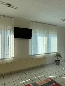 a room with white windows and a flat screen tv at Apartment Natali in Schnaittenbach