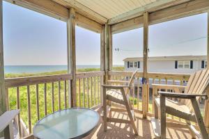 a screened porch with two chairs and a glass table at AV2D - By The Sea in Nags Head