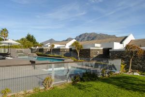 a house with a fence around a swimming pool at Stellenbosch Luxury Apartments in Stellenbosch