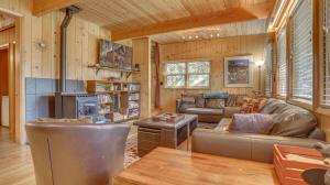 a living room with leather furniture and a fireplace at Moosewood Cabin - Meredith Lodging in Government Camp