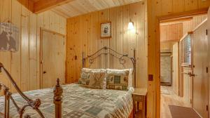a bedroom with a bed in a room with wooden walls at Moosewood Cabin - Meredith Lodging in Government Camp