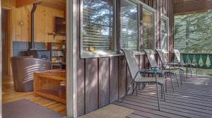 a screened in porch with chairs and a table at Moosewood Cabin - Meredith Lodging in Government Camp