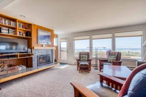a living room with a fireplace and a tv at Breakers Beach House 7 in Neskowin