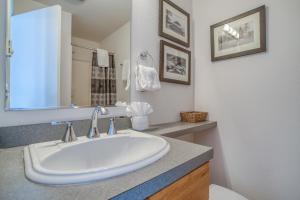 a white bathroom with a sink and a mirror at Breakers Beach House 7 in Neskowin +36 photos