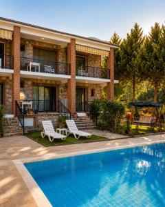 a house with a swimming pool in front of a house at Doğa Pansiyon in Marmaris +11 photos
