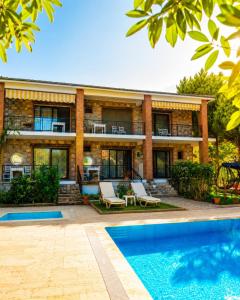 a house with a swimming pool in front of it at Doğa Pansiyon in Marmaris