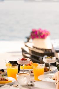 a table with plates of food and glasses of orange juice at H - Suites in Poreč