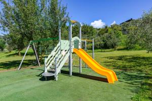 a playground with a slide in a park at Park Hotel Val Di Monte ***S in Malcesine