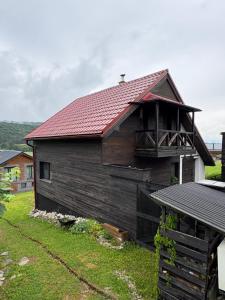 a wooden house with a red roof on a yard at Chata Snowee Valča in Stará Turá