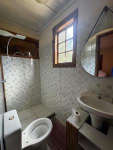 a bathroom with a toilet and a sink and a mirror at Retiro Real in Santo Antônio do Leite