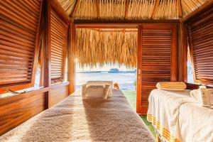two beds in a room with a view of the ocean at Mangrove Beach Corendon Curacao All-Inclusive Resort, Curio by Hilton in Willemstad