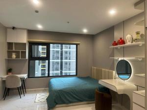 a bedroom with a bed and a desk and a window at Alex Vinhomes Grand in Gò Công