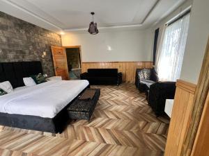 a bedroom with a bed and a chair and a couch at Pine Peaks Heaven in Nathia Gali