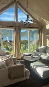 a living room with two couches and a large window at Haukland beach panorama - with Sauna in Offersøya