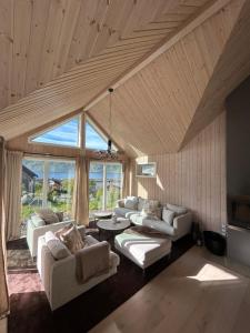 a living room with white furniture and a large window at Haukland beach panorama - with Sauna in Offersøya +23 photos