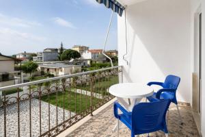 a balcony with a white table and blue chairs at Hotel Aleksi Velipojë in Velipojë