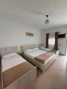 a bedroom with two beds and a window at Hotel Aleksi Velipojë in Velipojë