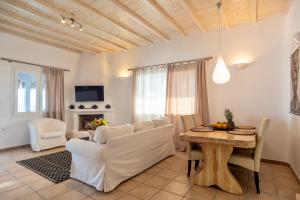 a living room with white furniture and a table at Infinity View Villas Mykonos in Kalo Livadi