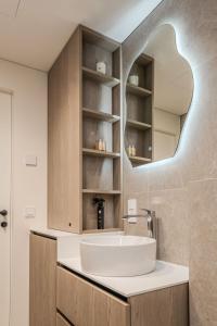 a bathroom with a sink and a mirror at Nida Breeze Apartments in Neringa +15 photos