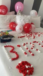 a table with red roses and decorations on a bed at Elitha Boutique Bed and Breakfast in Mogwase